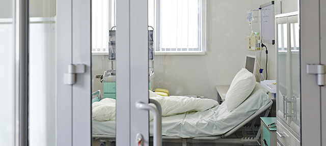 photo - Empty ICU Bed Behind Glass Door