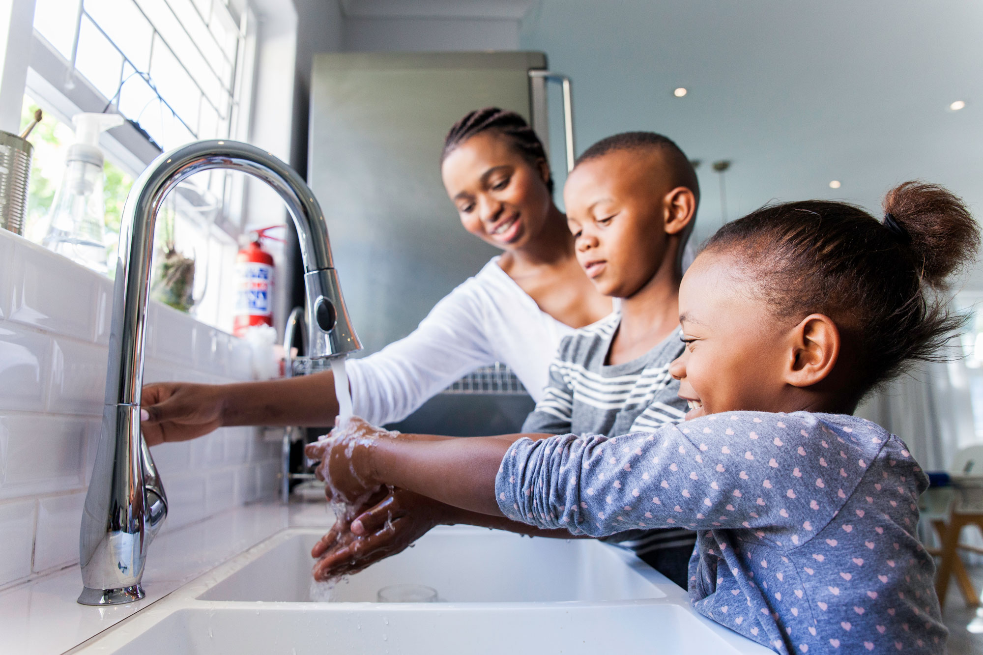 photo - Family Washing Their Hands Together at Kitchen Sink