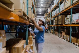 photo - Female Employee Counts Inventory in Warehouse