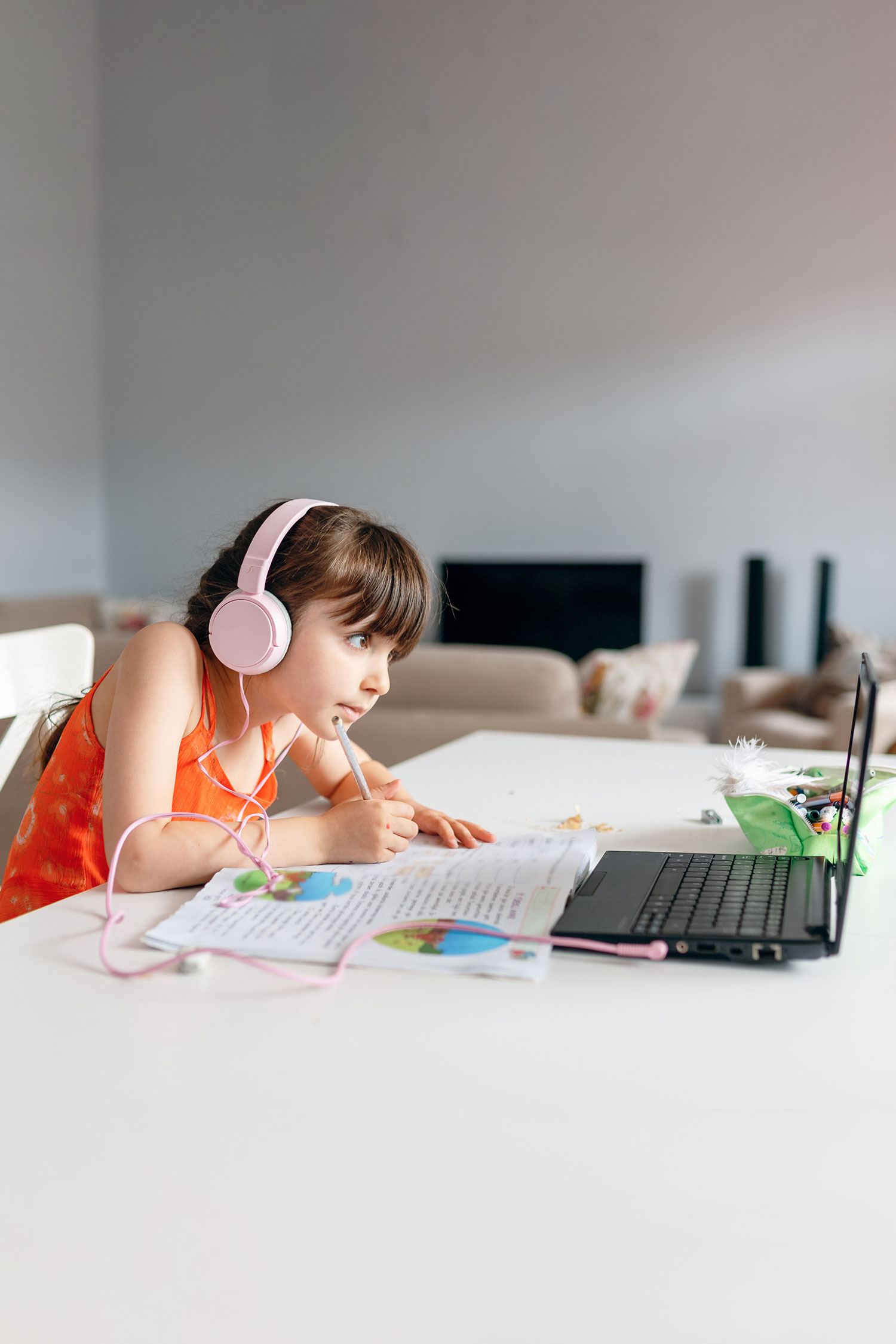 photo - girl wearing headphones and using laptop