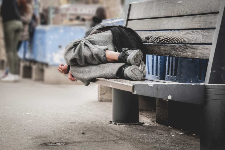 photo - homeless man sleeping on a bench