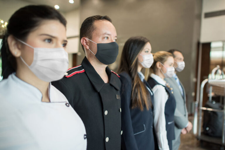 photo - Hotel Workers Wearing Facemasks Standing in a Row