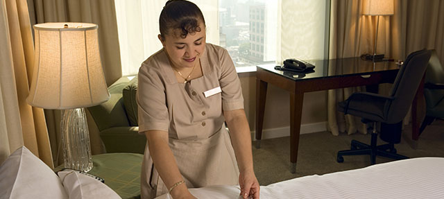 photo - Maid Making Bed In Hotel