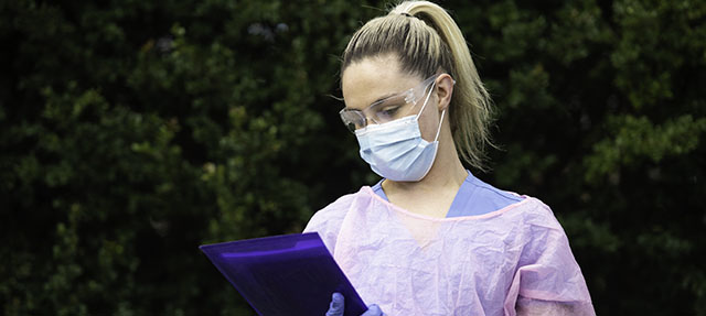 photo - Nurse Wearing Protective Workwear and Holding Paperwork