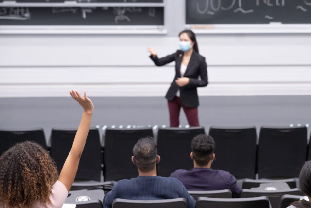 photo - Professor Wearing Mask and Lecturing to Students