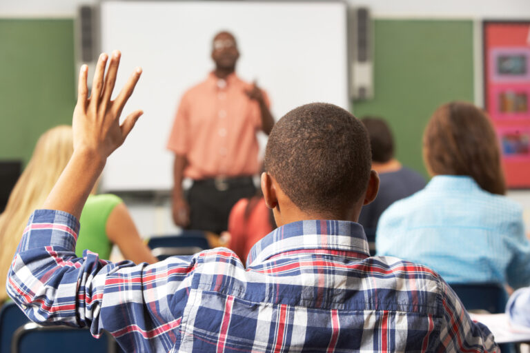 photo - Rear view of Student Raising Hand in Classroom
