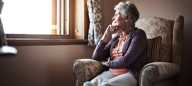 photo - Senior Woman Sitting Alone in Livingroom
