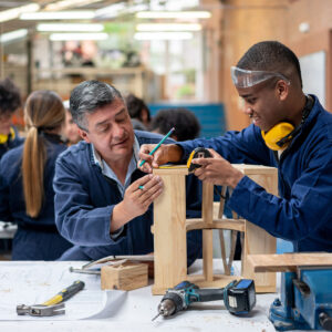 photo - Student Building Furniture with Help from Teacher