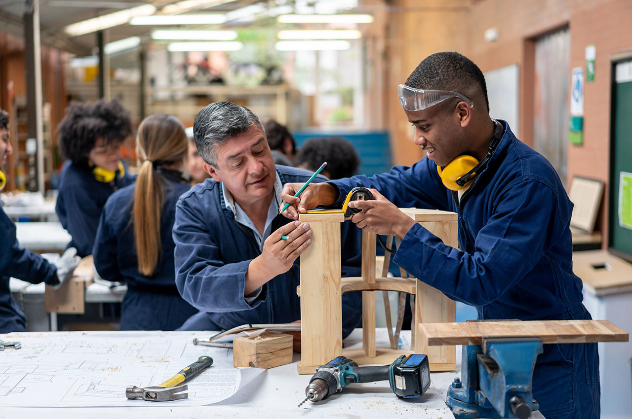 photo - Student Building Furniture with Help From Teacher