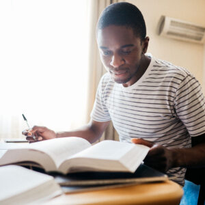 photo - Student of Color Studying in Dorm