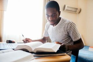 photo - Student of Color Studying in Dorm