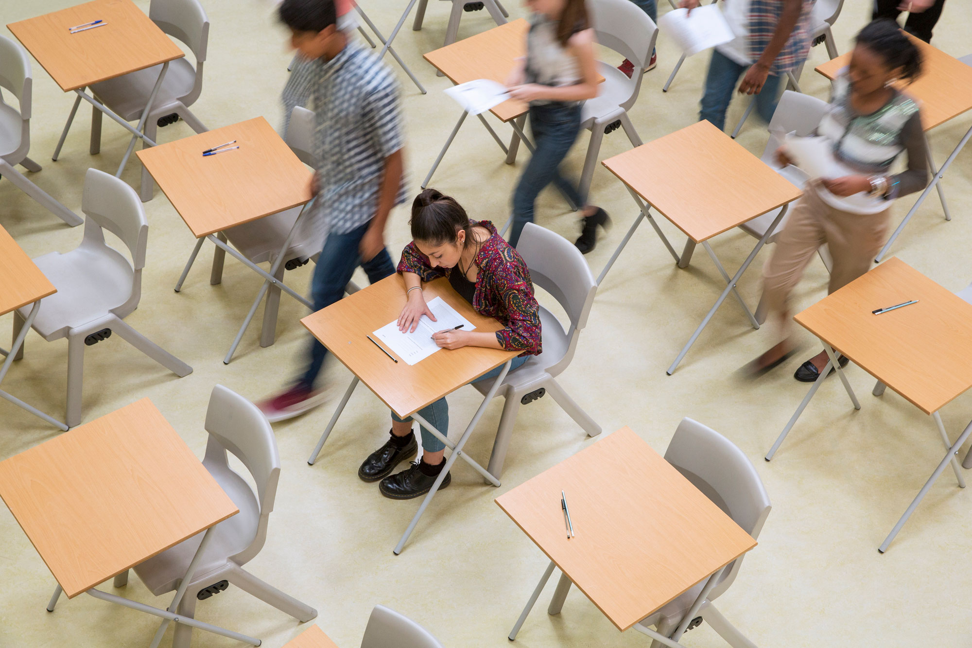 photo - Elevated view of students taking a test in a partially empty classroom