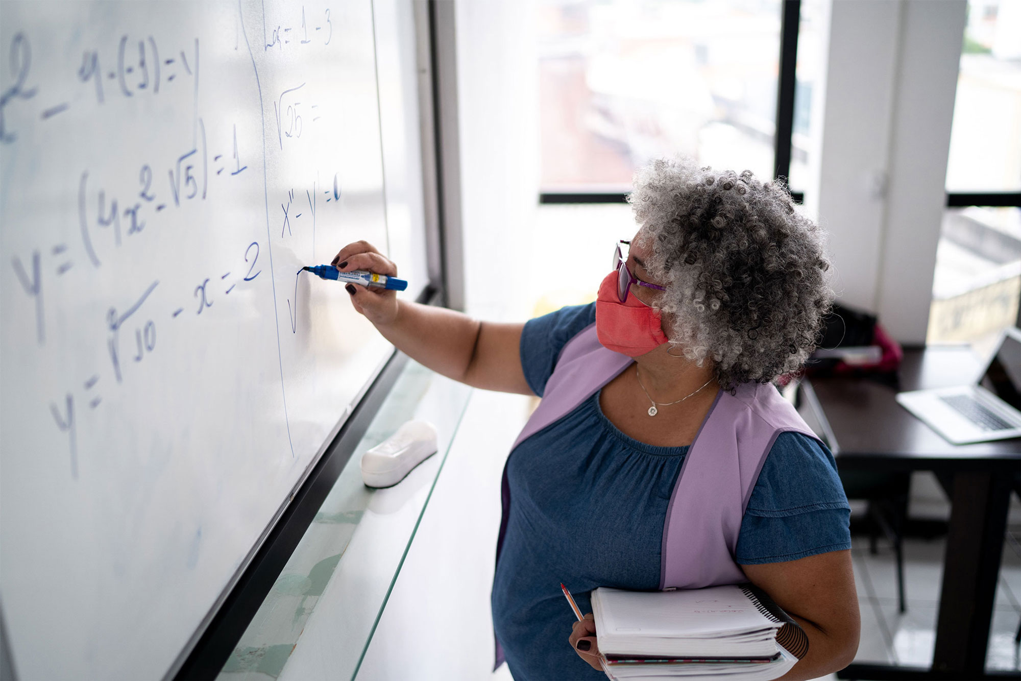 photo - Teacher Writing Equations on Whiteboard and Wearing Face Mask