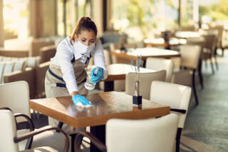 photo - Waitress Wearing a Mask and Gloves, Disinfecting Tables in a Restaurant