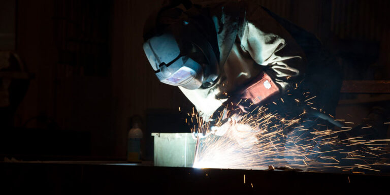 photo - A welder working in a dark room