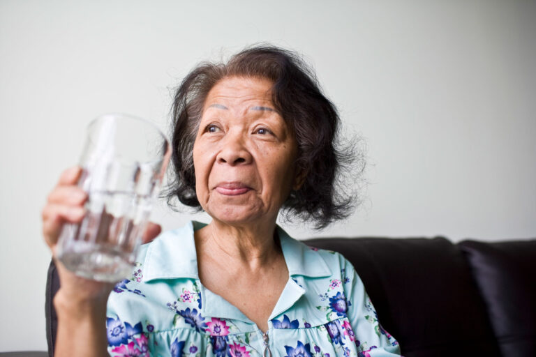 photo - Woman Holding a Glass of Water