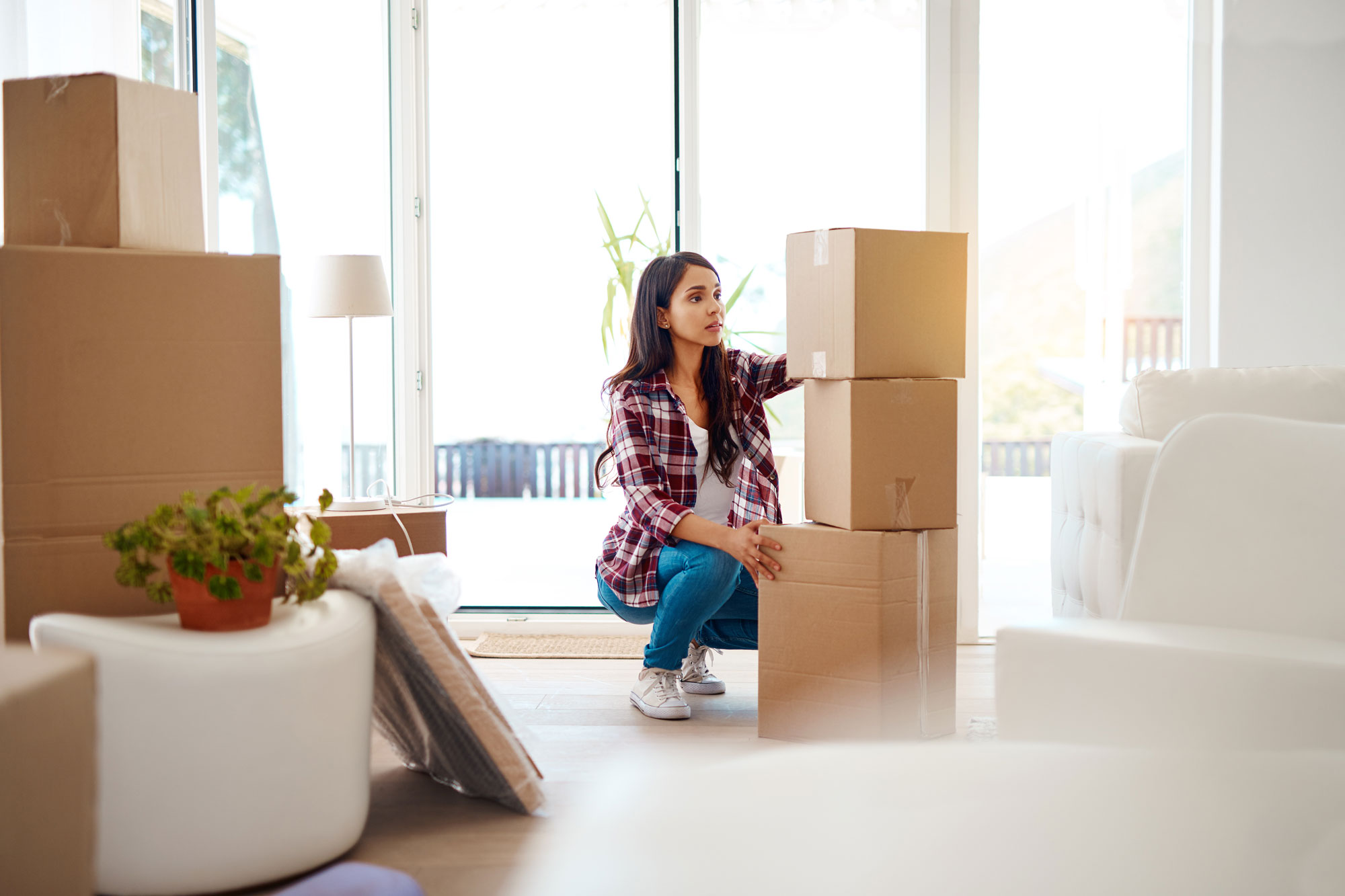 photo - Woman Packing and Stacking Moving Boxes