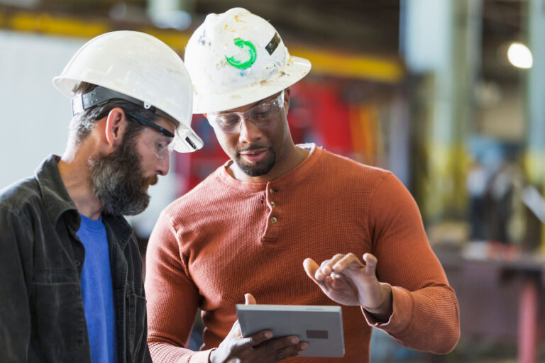 photo - Two workers in discussion while using a tablet