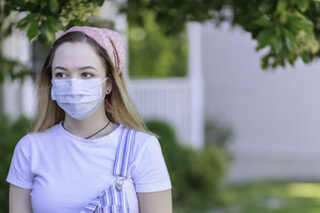 photo - Young Adult Wearing a Mask
