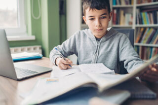 photo - Young Boy Doing Schoolwork at Home